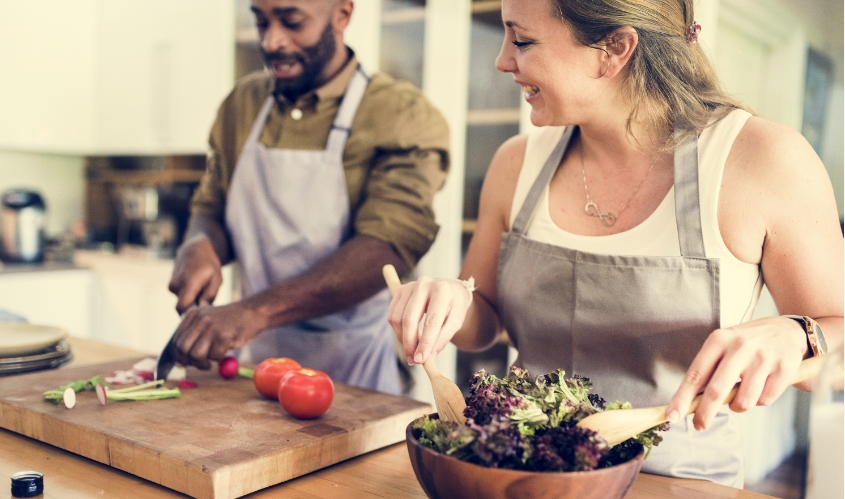 Man and woman prepare a salad in a kitchen at The Adelaide